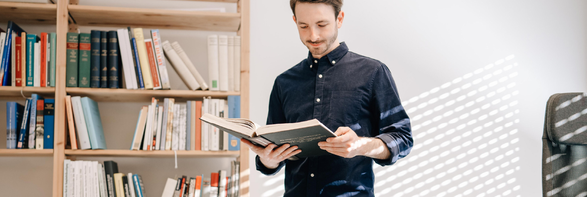 Person hält ein aufgeschlagenes Buch